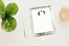 Clear acrylic notepad with a color pet ears printed image on a white surface with a pen and plant.