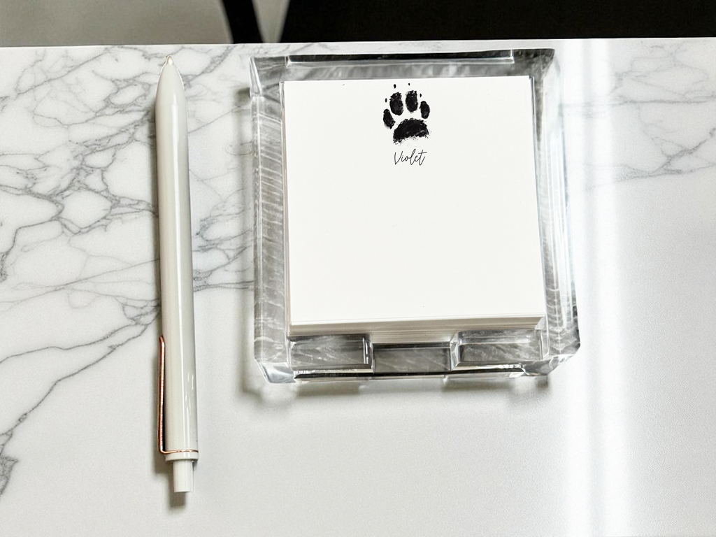 Acrylic notepad with custom paw print design with pen and paw print design on marble surface