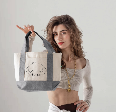 Woman holding a tote bag with a design on a plain background