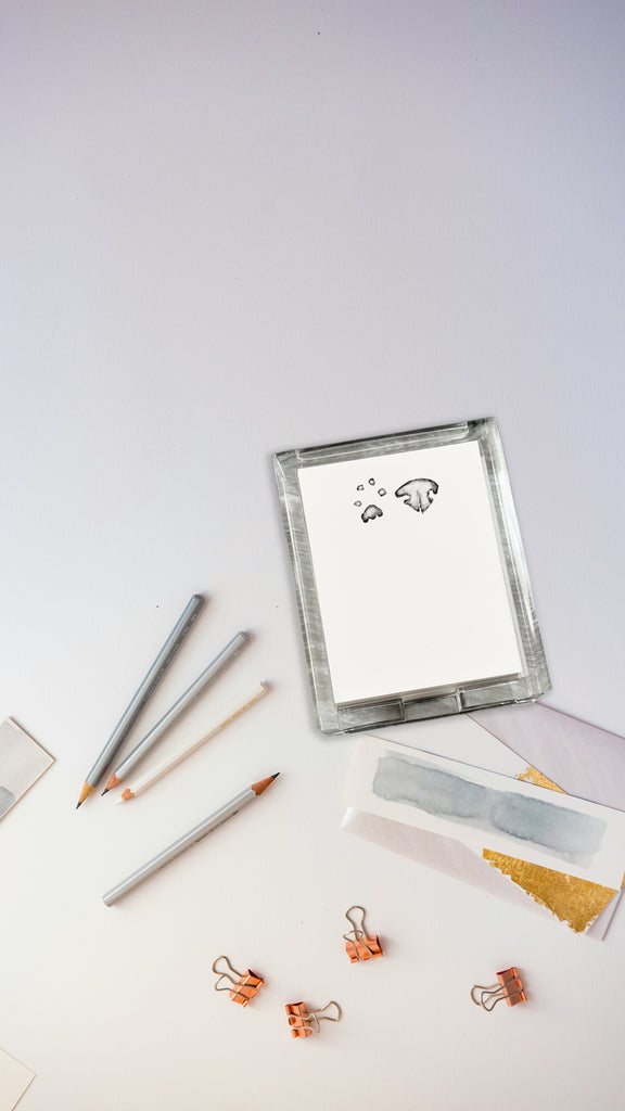 Acrylic notepad holder with custom nose or paw impression design with stationery items on a white background