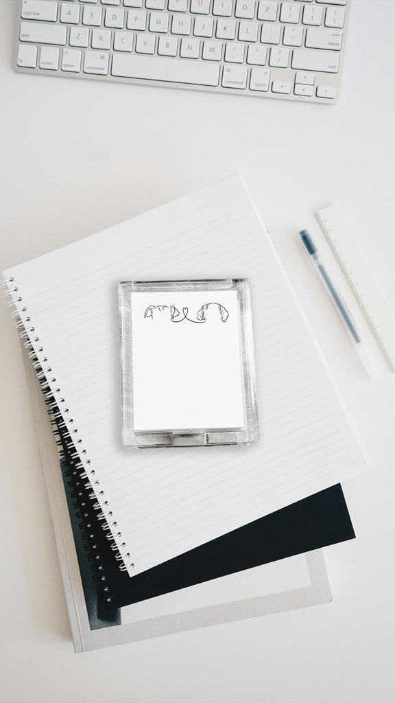 Acrylic notepad holder with custom pet ears design, pen, and keyboard on a light surface 