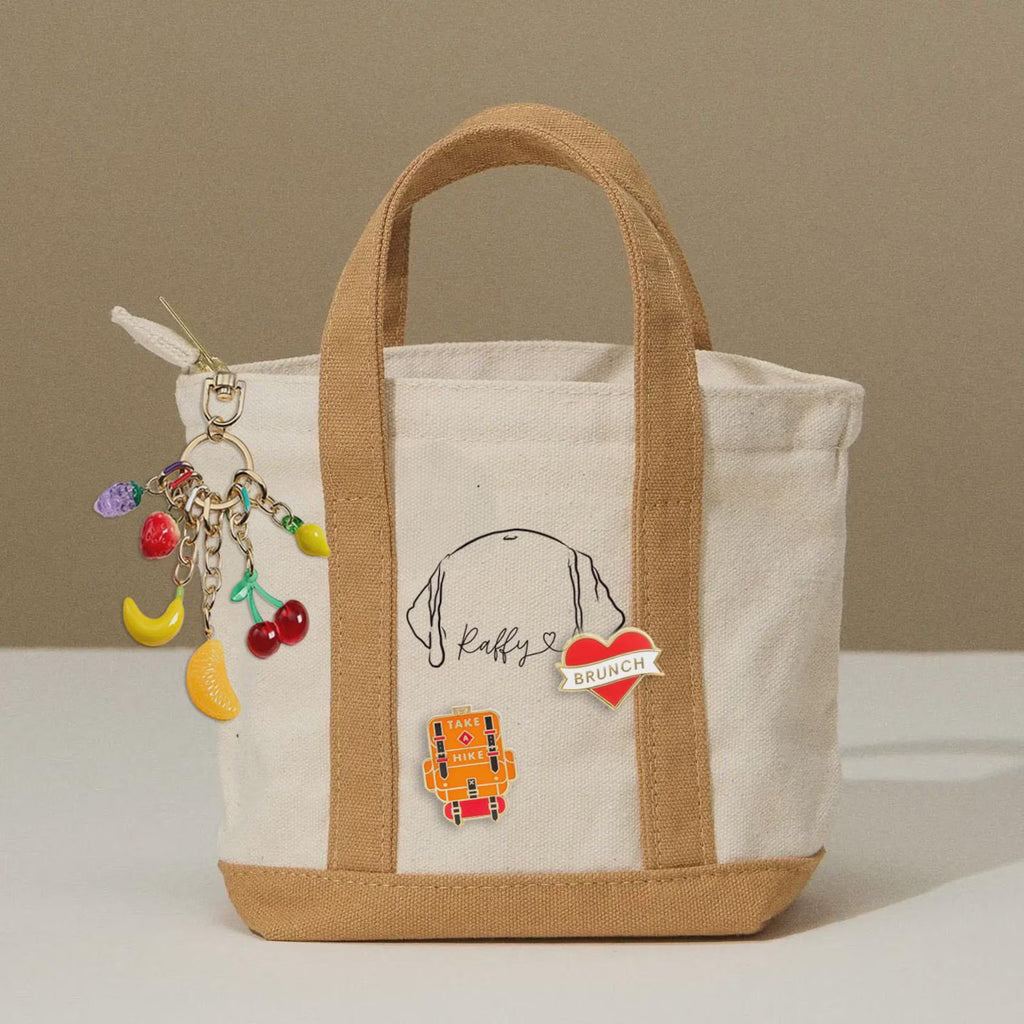 The Mini Eco Charm Tote is a sleek and compact bag designed for effortless everyday use. Crafted from eco-friendly, durable cotton canvas, this bag is lightweight yet sturdy, making it a perfect choice for those who need a stylish, minimal carry-all. 