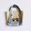Tote bag with custom dog illustrations and text on a white background