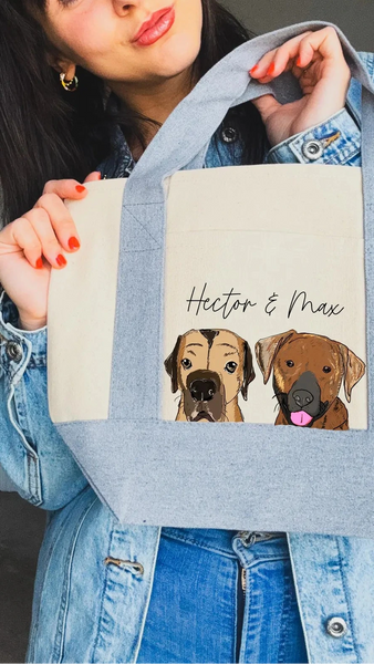 Person holding a mini tote bag with dog portraits and text