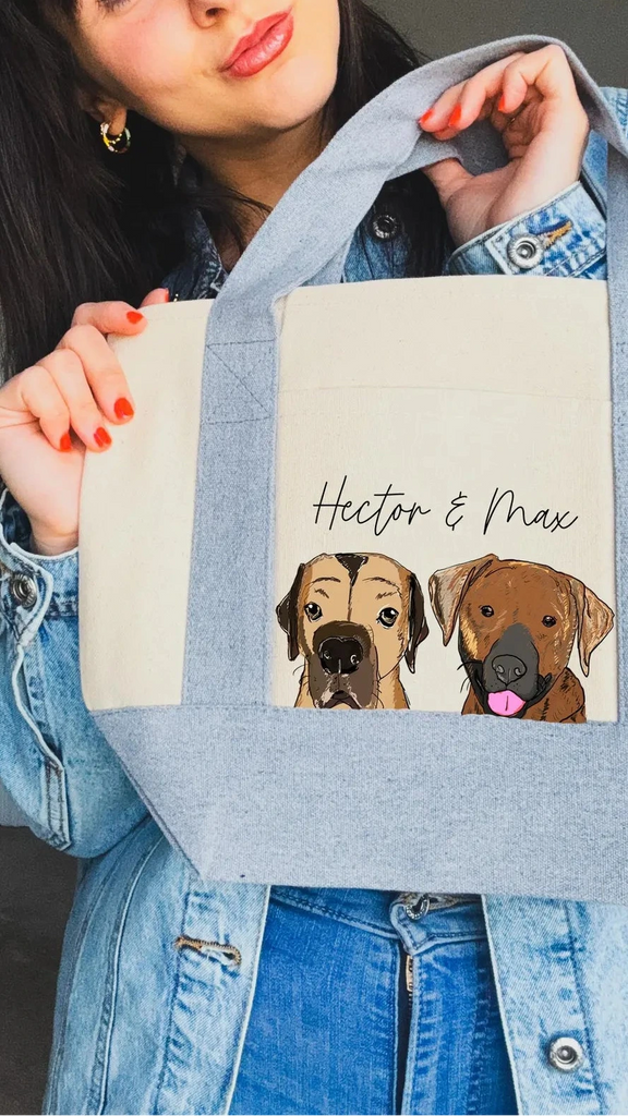 Person holding a mini tote bag with dog portraits and text