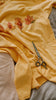 Yellow t-shirt with custom paw prints on autumn leaves design and a pair of scissors on a bed.