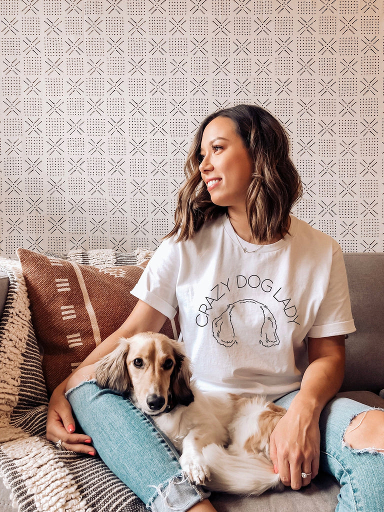 Dachshund sitting next to a model wearing a t-shirt. Barkley & Wagz customized Crazy Dog Lady or other dog mom sayings T-Shirt in white.
