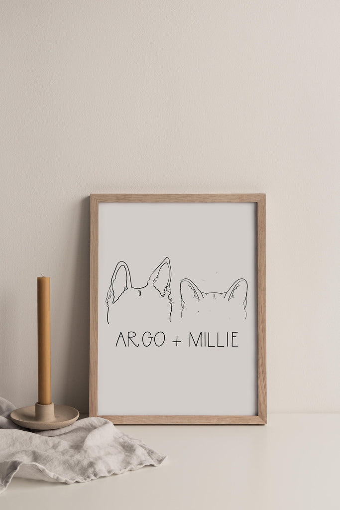 8"x10" art print featuring a hand drawn illustration of dog and cat ears, framed in a wooden frame and in black and white.